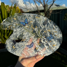 Handmade resin paint palette with pearlescent swirl finish, embedded blue butterflies, dried botanical accents and gold leaf flakes, artist mixing palette for acrylic, watercolour and resin art.