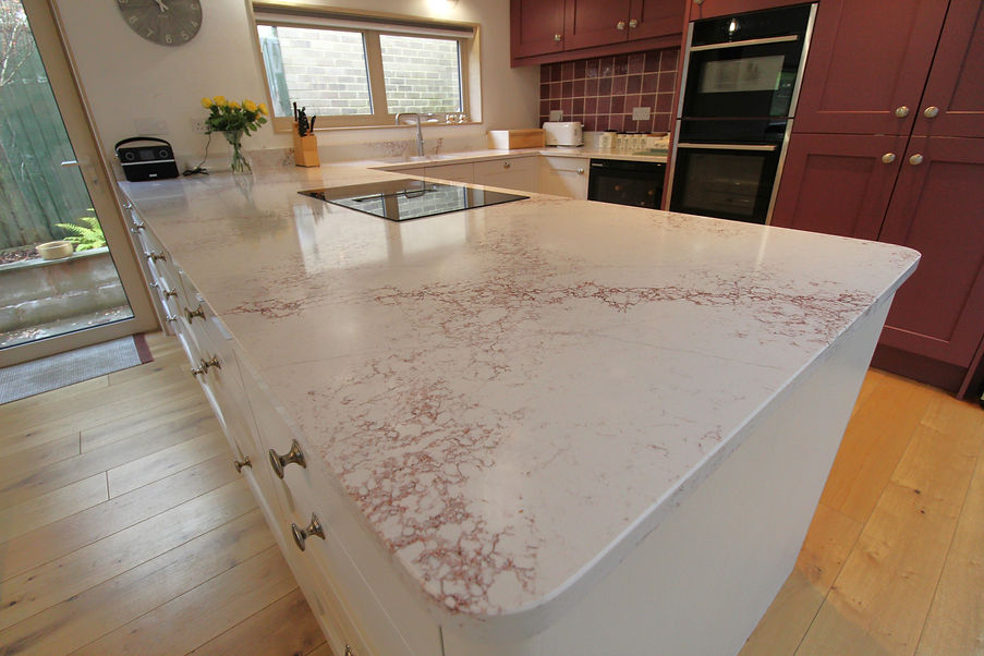 A modern kitchen featuring a white countertop and vibrant red cabinets