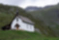 A white timber framed chapel on a hill.