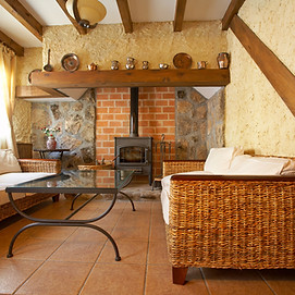 A small living room with wood beams on the ceiling.