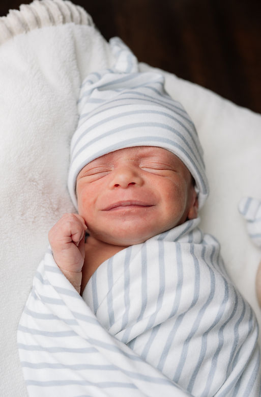 Newborn baby lying down smiling