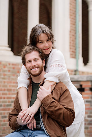 woman close to man draping her arms over him