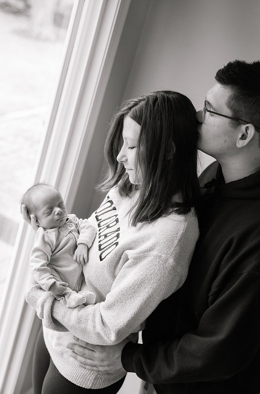 Mom and dad gathered together holding their newborn