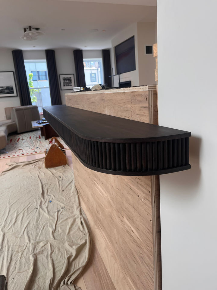 Rounded end of the walnut bar top, showing the tambour wrapping the curve.