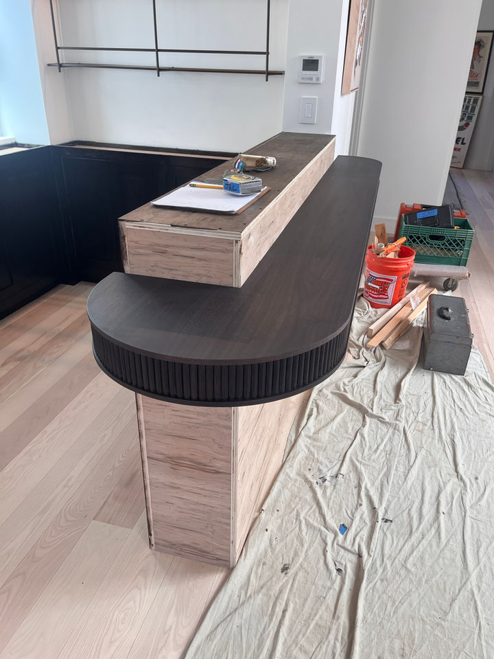 Iron walnut bar top with a radius end on the day of install, before the marble cladding went on.