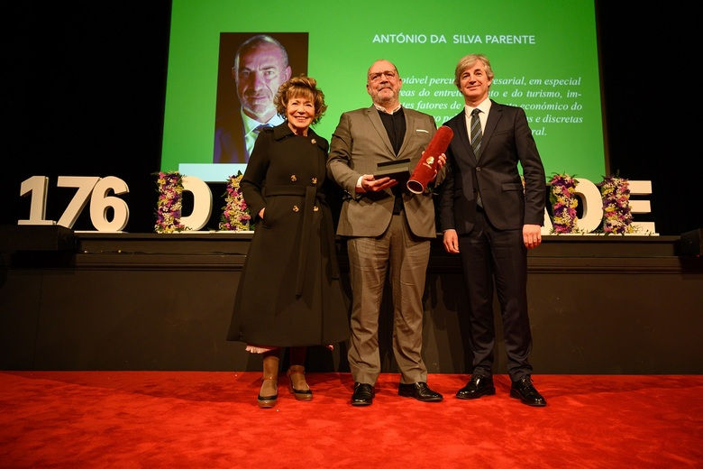 homem segurando um canudo na mão, ladeado por uma mulher e um homem