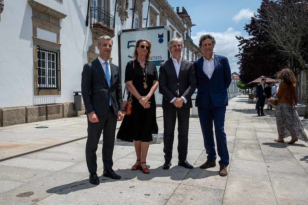 três homens e uma mulher junto a uma exposição na rua
