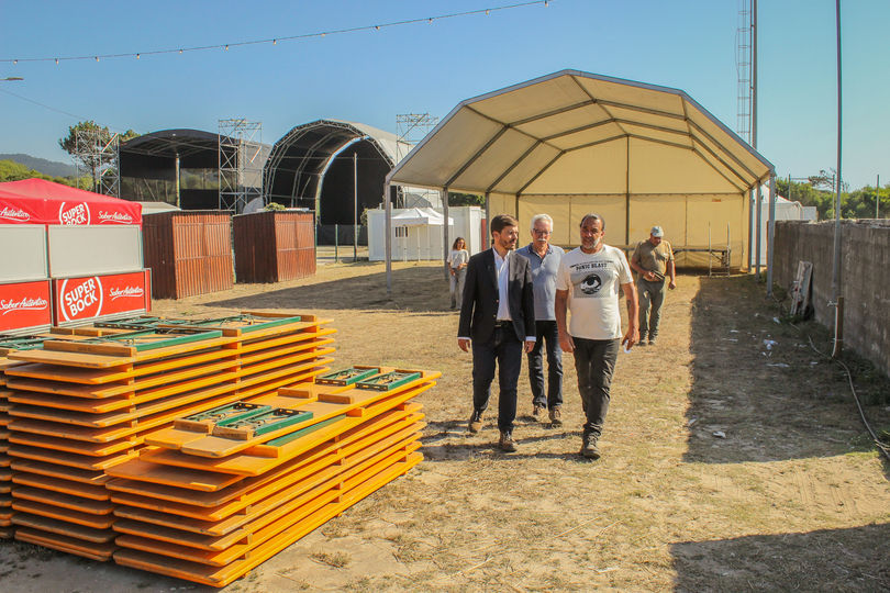 homens passeando num recinto preparado para acolher um festival de música