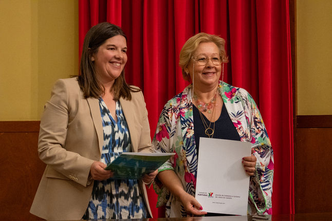 duas mulheres exibindo folhas nas mãos, sorridentes