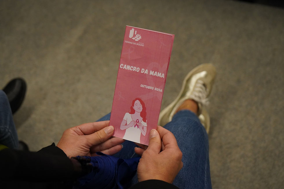 mulher segurando num panfleto sobre o movimento Outubro Rosa - Cancro da Mama