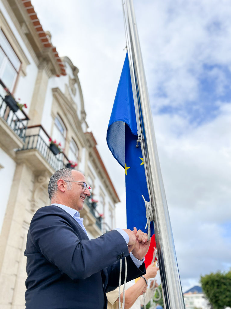 homem içando uma bandeira da União Europeia