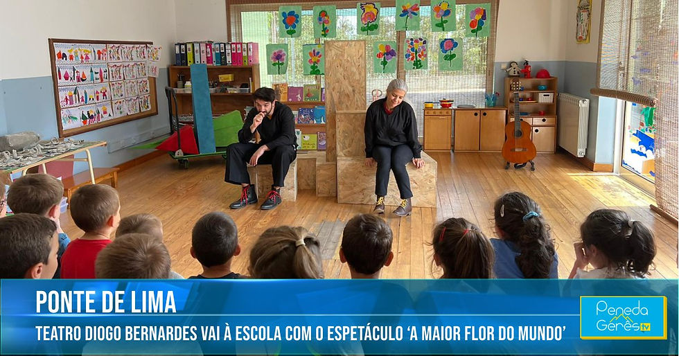 mulher e homem sentados em caixas de madeira contando uma história a crianças numa escola