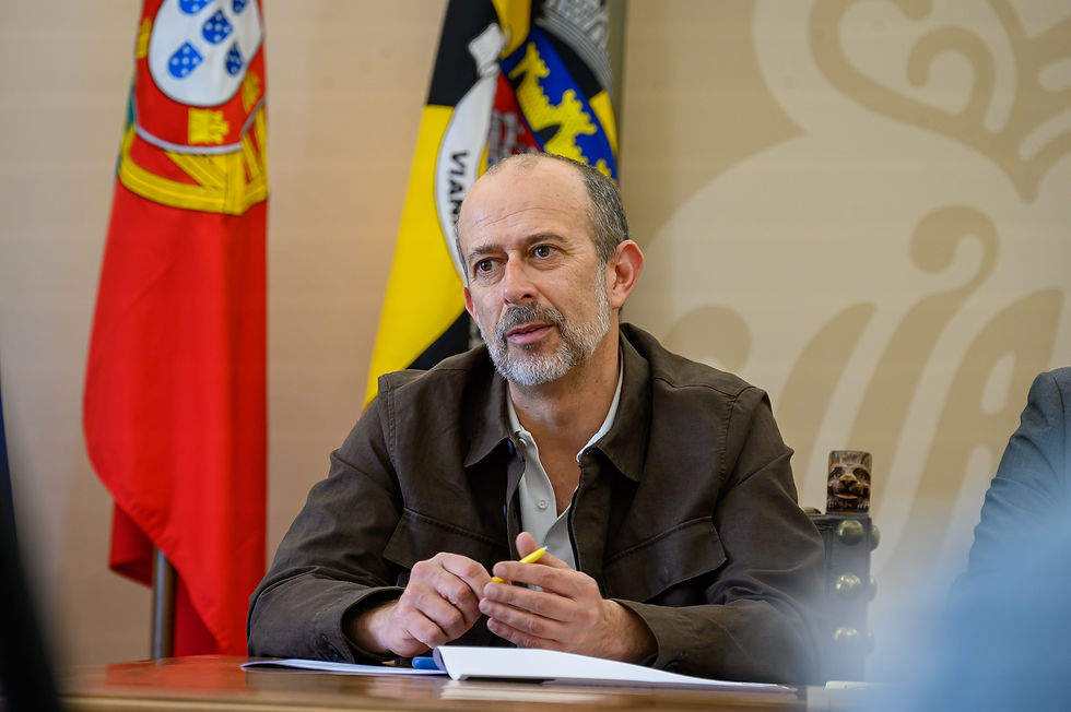 homem de meia idade, segurando uma caneta na mão, vestindo casaco castanho