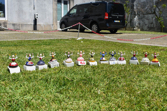 bonecos em madeira pintados e a repousar na relva