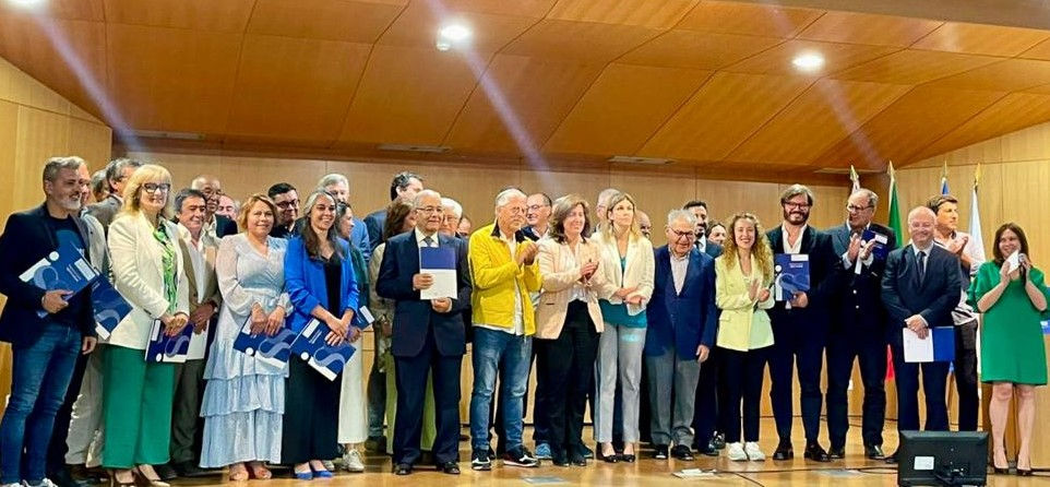várias pessoas em cima de um palco com dossiers na mão