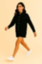 Woman walking in black co-ord set smiling. Skynn