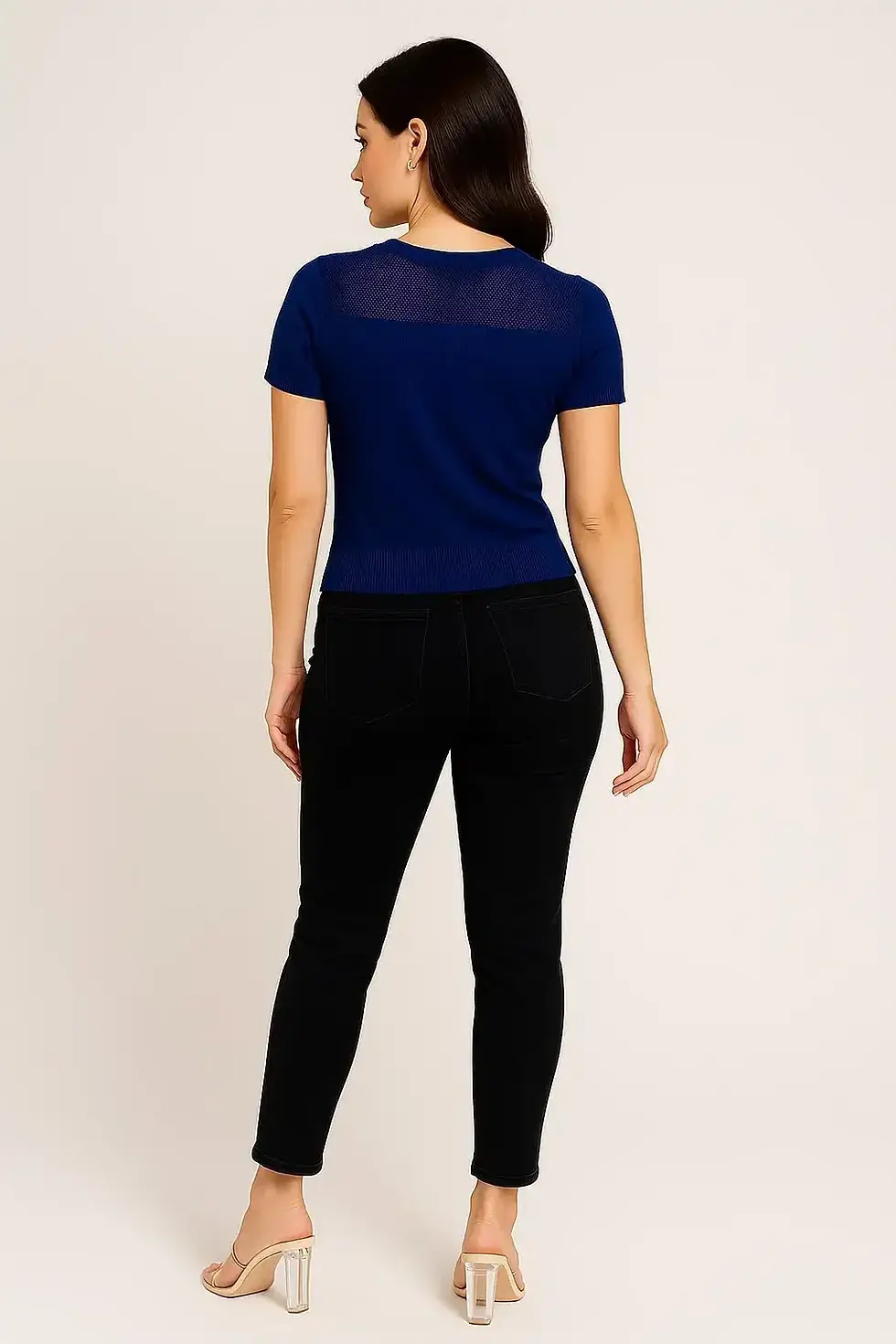 Thumbnail: Woman in blue shirt and black pants posing, product shot Skynn.