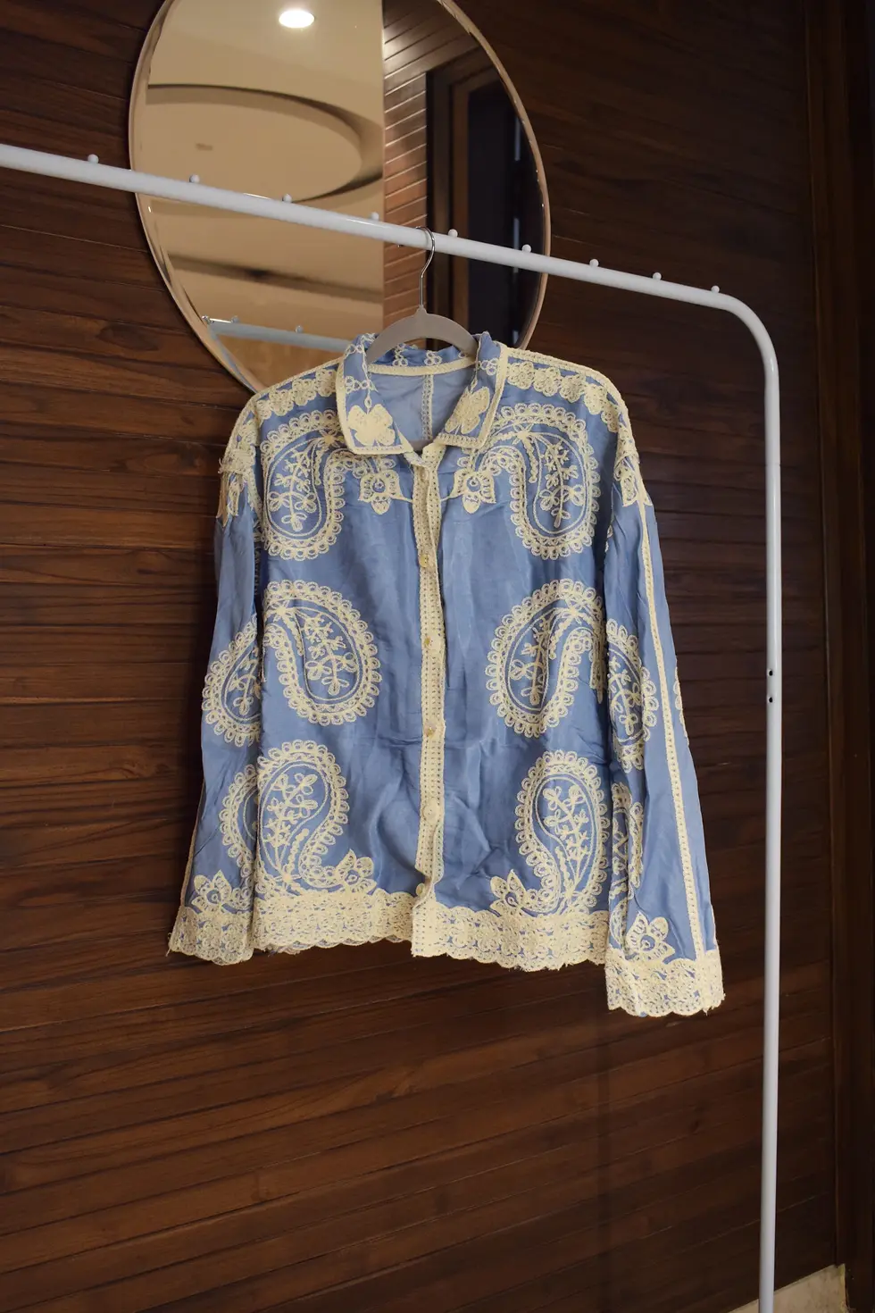 Thumbnail: Blue paisley jacket hanging on a rack with a mirror in the background.
