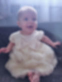 Happy baby in dress smiling for pictures