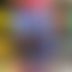 Hand holds a book titled "These Stolen Lives" by Sharada Keats. Cover shows a dramatic coastline with small red boats. Blurred bookshelf behind.