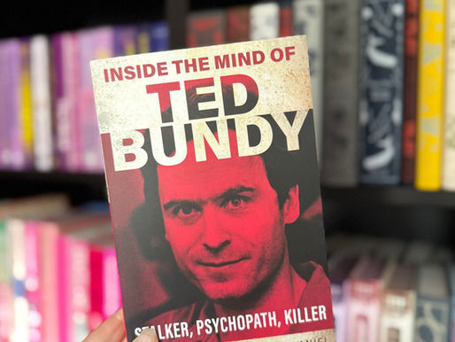 Hand holds a red-toned book titled "Inside the Mind of Ted Bundy" in a colorful library setting. Visible text includes "Stalker, Psychopath, Killer."