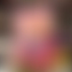 Person holding a pink book titled "Heart Racer" by Megan Avery, featuring illustrated characters. Bookshelves with colorful books in background.