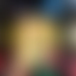 Hand holding a limited edition proof book with a yellow cover, featuring a black silhouette of a woman. Bookshelf with colorful books in background.