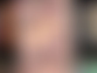 A hand holds a "Twilight" book by Stephenie Meyer with a floral cover. Blurred colorful books are in the background.