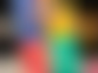 Hand holding the book "Lessons in Chemistry" by Bonnie Garmus against a bookshelf. Cover features a vintage TV illustration and vibrant colors.