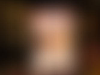 A hand holds a tablet displaying the book cover "Buckskin Brigades" by L. Ron Hubbard. Bookshelves full of colorful books are in the background.