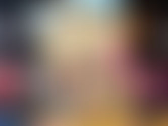 Hand holding "The Strawberry Patch Pancake House" book with colorful cover featuring a cozy café scene. Blurred bookshelves in background.