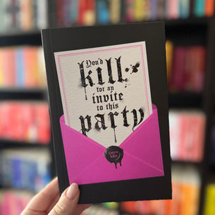 Hand holding a book with gothic text "You'd kill for an invite to this party," in a pink envelope. Colorful blurred bookshelves in background.