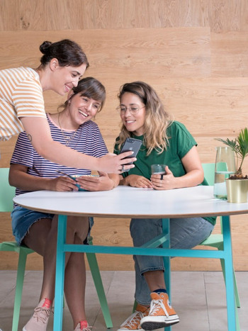3 Wix employees looking at a mobile screen with excitement