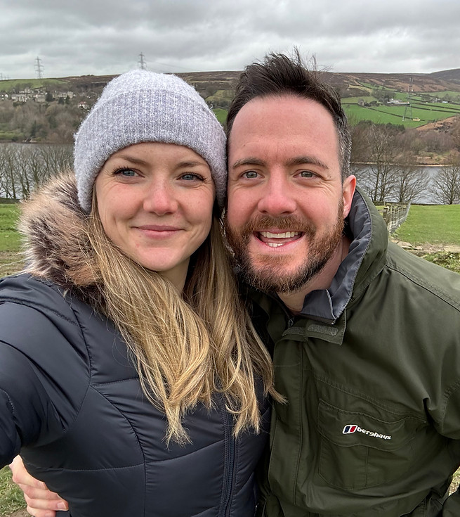 man and woman smiling with reservoir in the background.