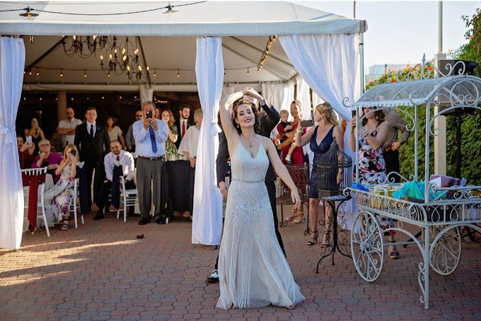 The groom leading the bride in an underarm turn during their first dance at their wedding.