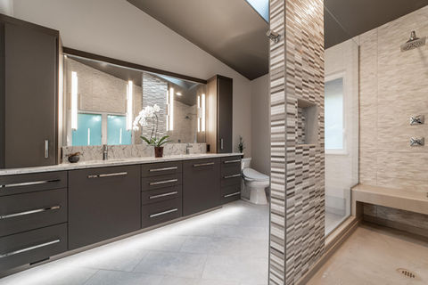 This house, from 2002, was transformed into a modern, everyday haven. A large shower with four body sprays and a rain head replaced the large built-in tub in the redesign. With its heated porcelain floors, dark grey vaulted ceiling, and floating vanity with built-in motion-sensor lighting, this project won an OMB Tour of Homes award in 2019 and NKBA Puget Sound's First Place for Large Bathroom.