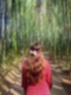 A solo traveler among tall, green bamboo groves in Japan