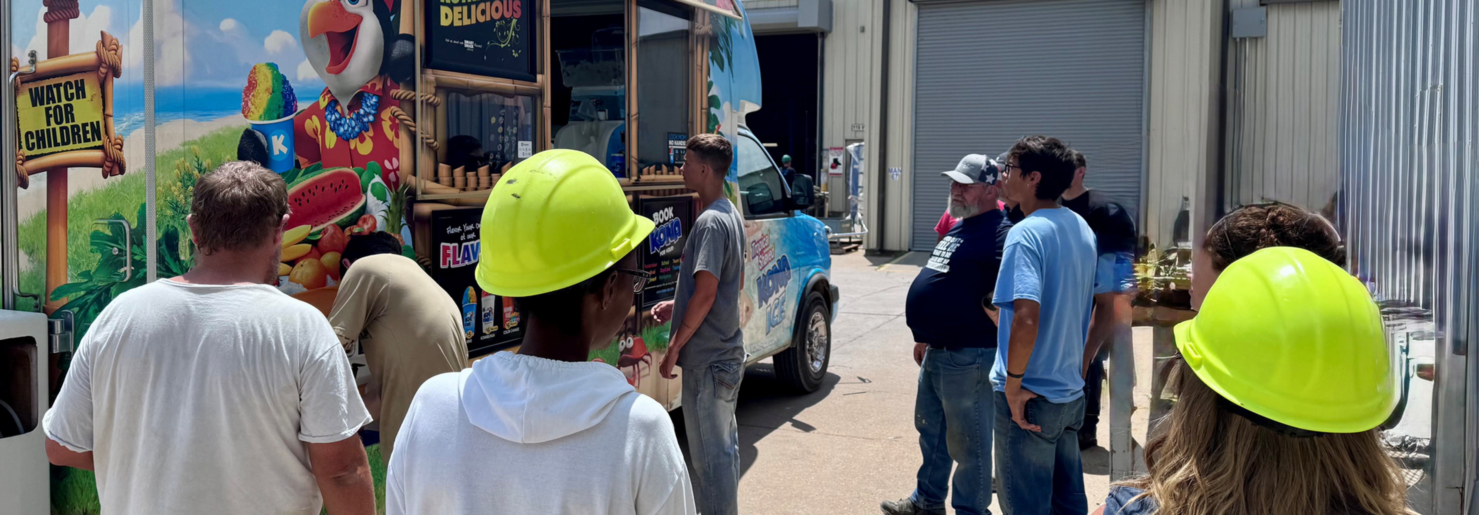 Sunbelt Solomon employees gather outside the Kona Ice truck during the annual Summer Cool Down event as they enjoy a break from work on a warm summer afternoon.