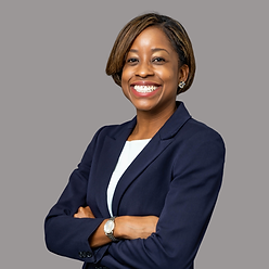 Black business woman wearing a navy suit with arms folded, smiling at camera