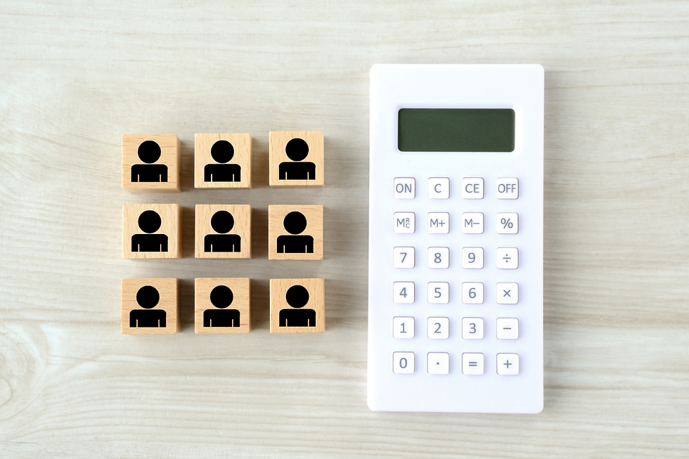 Nine person icons on wooden blocks beside a white calculator on a pale wood surface.