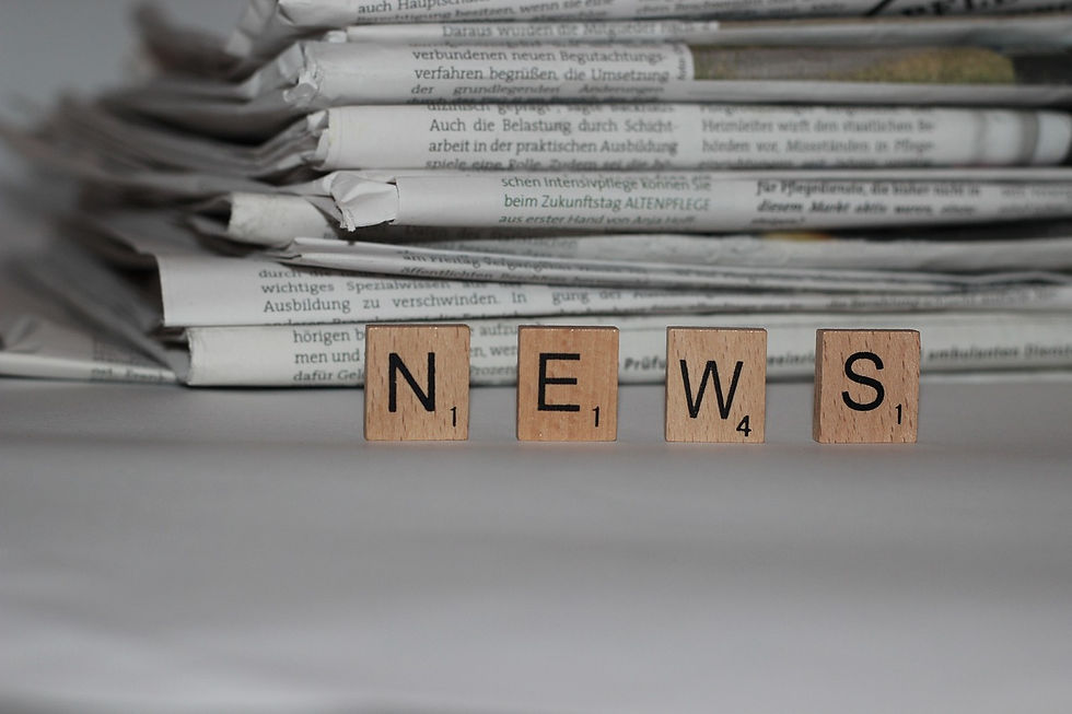 stack of newspapers with scrabble words spelling news