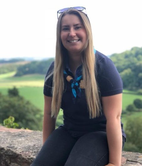 Girlguiding Cornwall volunteer sitting outdoors overlooking countryside