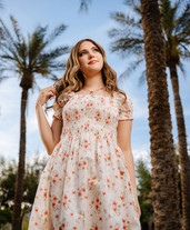 A girl playing with her hair in front of palm trees