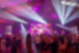 Event integracyjny firmy – uczestnicy podczas wieczornego wydarzenia firmowego z oprawą świetlną i muzyczną, budującego relacje zespołowe.