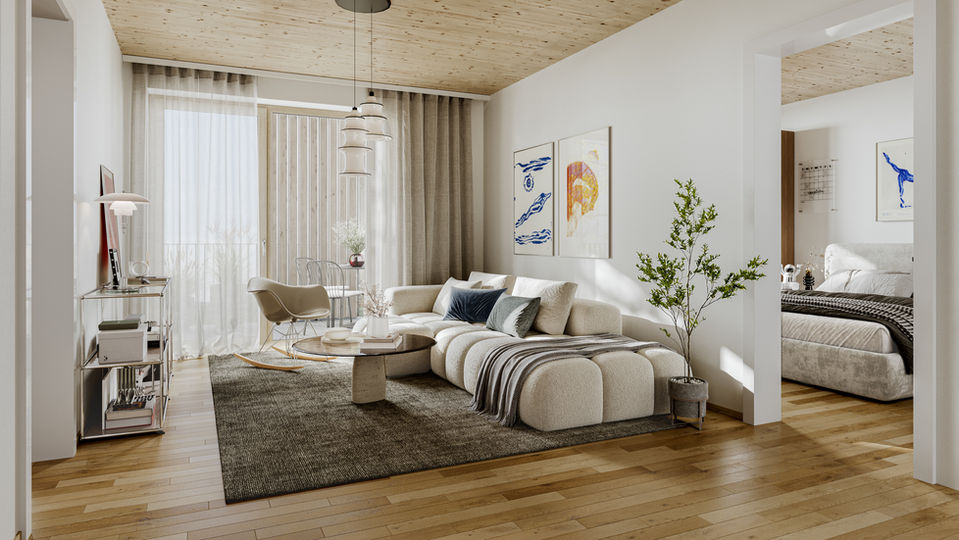 Ein Wohnzimmer mit einem großen Sofa auf der linken Seite und einem Regal rechts, Links ist außerdem noch der Durchgang in ein Schalfzimmer zu sehen