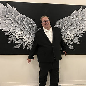 Ray Warner stands in front of angel wings.