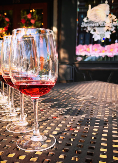 Wine glasses lined up for a guided tasting on the patio outside Farmer's Daughter