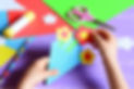 Small child makes paper crafts for mother's day or birthday. Small child doing paper flowe