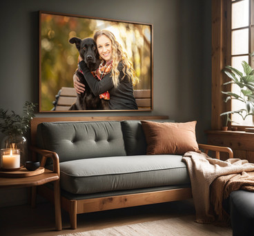 Portrait of owner and dog hanging above couch