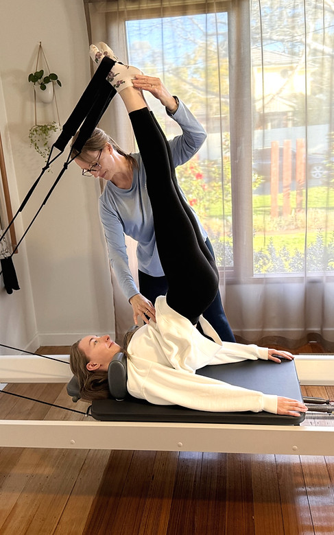 The client is in a private class conducting a challenging exercise with the assistance of the instructor